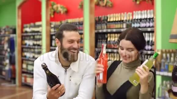 一对漂亮的夫妇在超市里选择香槟和白酒跳舞视频的预览图