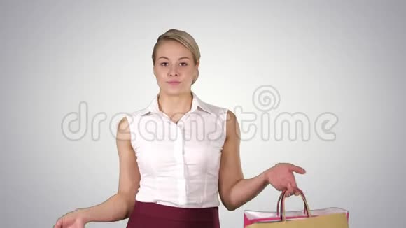 年轻女子一边走路一边拿着购物袋一边购物阿尔法频道视频的预览图