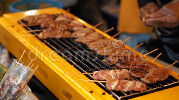 鲜肉在烤架上的木串上慢动作美味的烧烤在户外炒视频的预览图