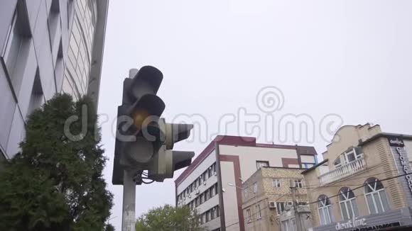 街道上的黑色交通灯与周围的建筑物和树木闪烁视频的预览图