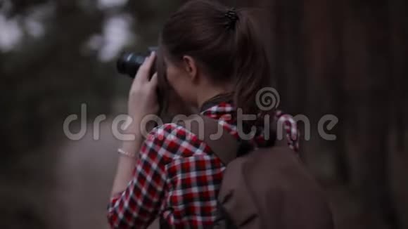旅游女摄影师在森林中徒步旅行后视图视频的预览图