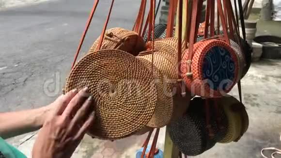 女人选择藤生态袋在巴厘岛印度尼西亚的艺术商店女人时尚的生态袋视频的预览图
