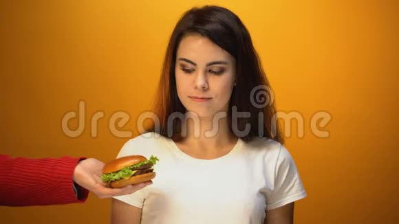 漂亮的女人选择沙拉而不是汉堡包医疗保健和垃圾食品视频的预览图