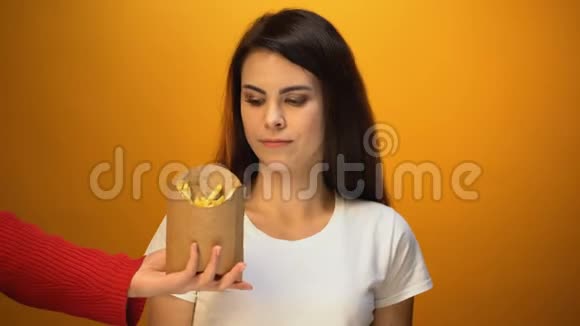 年轻女性选择新鲜沙拉而不是炸薯条健康饮食减肥视频的预览图