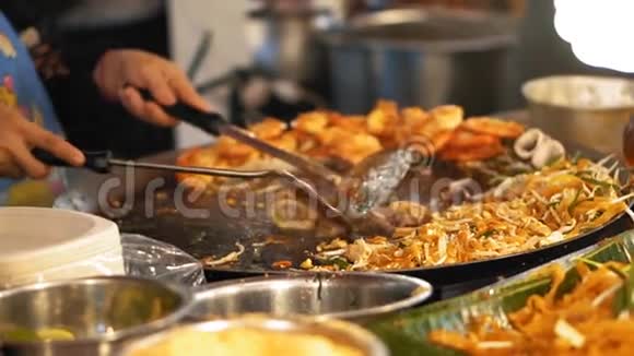慢动作厨师在热锅上烤着鱿鱼和章鱼一大道菜配上美味的沙拉和油炸食品视频的预览图