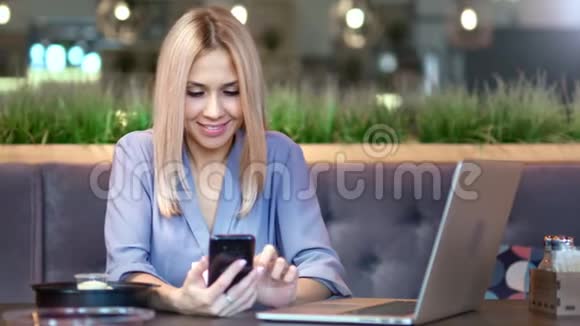 微笑的年轻女商人用智能手机打字或聊天的肖像视频的预览图