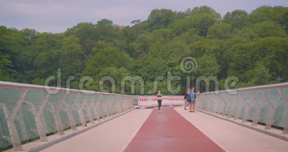 城市户外桥上跑步的年轻漂亮运动型女慢跑者的特写镜头视频的预览图
