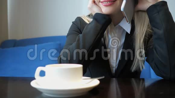 令人难以辨认的微笑年轻女子在咖啡馆喝咖啡时与人友好的电话交谈视频的预览图