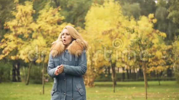女士穿着时髦的外套在等男朋友的时候冻僵了秋天的景象视频的预览图