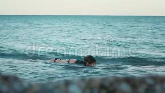 小女孩在海滩上爬进海里少女在海上度假放松视频的预览图