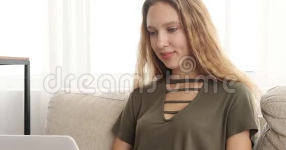 沙发上用笔记本电脑的时尚少女视频的预览图