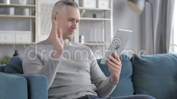 灰发男人在床上放松的在线视频聊天视频的预览图