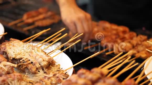 慢动作木串上的美味肉块放在热烤架上男性手拿烤肉串视频的预览图