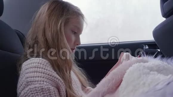 肖像女孩使用智能手机而旅行在后座的汽车轮廓视图视频的预览图