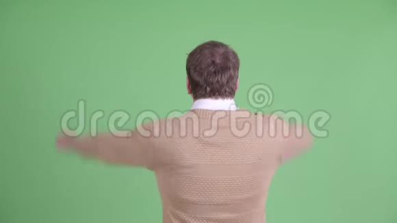 快乐超重留胡子举起拳头的男人的后视图视频的预览图