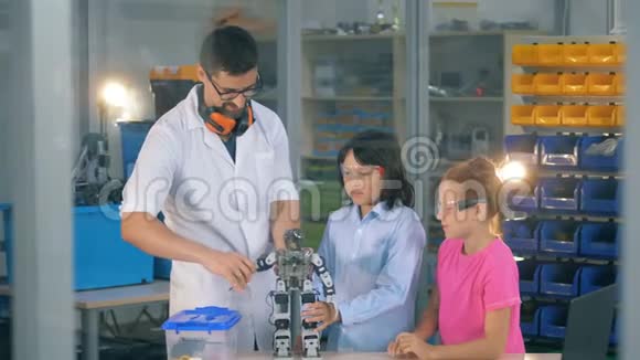 小孩子和一位研究专家正在移动机器人四肢视频的预览图