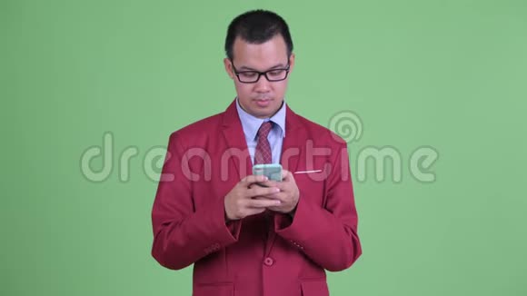 穿着打扮的亚洲商人用电话接坏消息视频的预览图