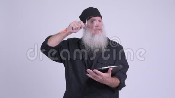 成熟的留着胡须的嬉皮士男子拿着剪贴板同时使用放大镜视频的预览图