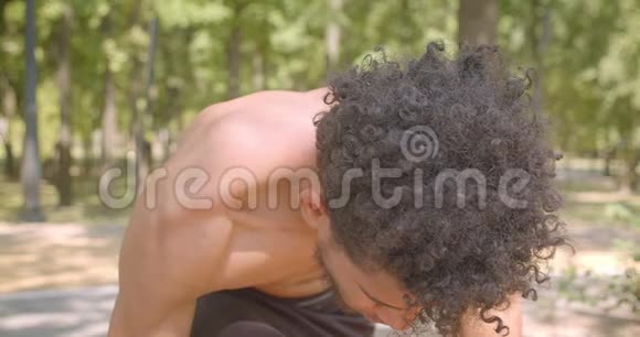 年轻健康的非裔美国男性慢跑者准备在户外公园跑步的特写镜头视频的预览图