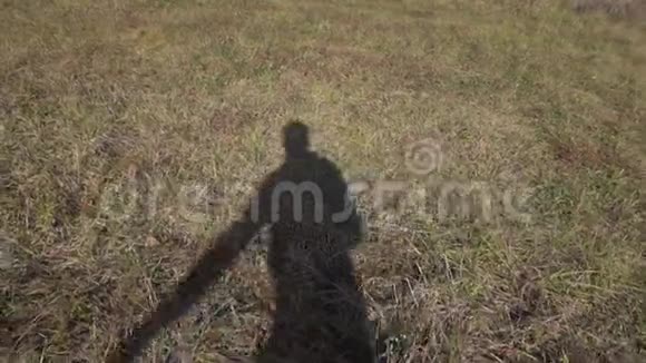 跳跃的影子苗条的人在浅棕色的地面上覆盖着厚厚的草视频的预览图