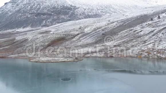 旅行者上升到一个高点他看着山峰和美丽的湖泊他拍摄了一幅美丽的风景视频的预览图