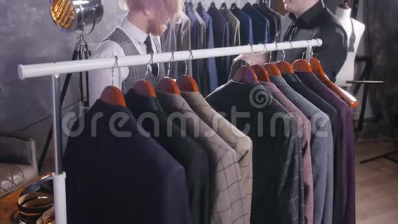 卖家帮助一个年轻优雅的男人在商店里选择一套经典的西装视频的预览图