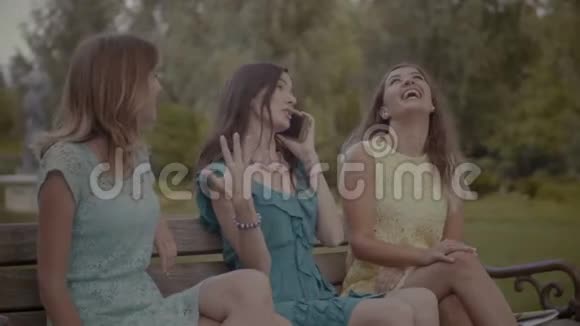 在公园的长凳上玩得开心的微笑女人视频的预览图