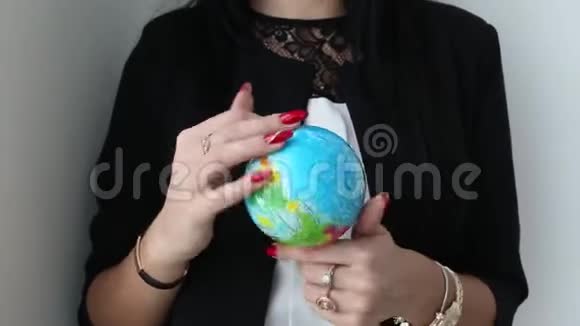 女性手握并旋转地球的玩具球球视频的预览图