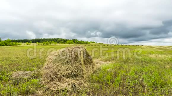 时间流逝的干草草地上的干草田野里的稻草堆田野上的浮云视频的预览图