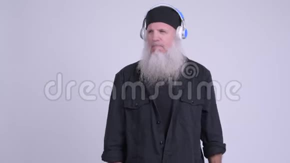 成熟的留胡子的时髦男人一边听音乐一边跳舞视频的预览图