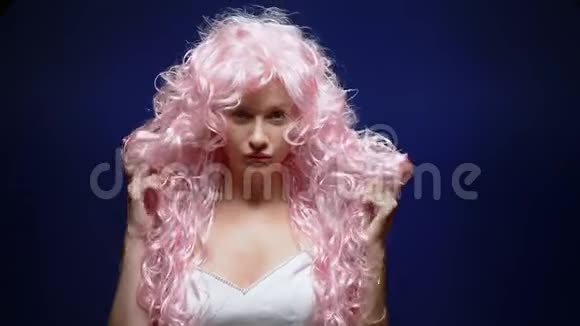 美丽可爱的女孩黑色背景上有一头粉红色的卷发视频的预览图