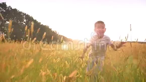美丽的亚洲快乐的孩子跑在草地上美丽的黄色景观视频的预览图