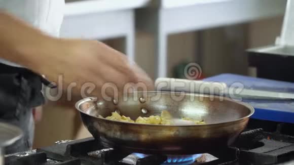 厨师把洋葱和腌制的蘑菇混合在煎锅里手的特写动作视频的预览图
