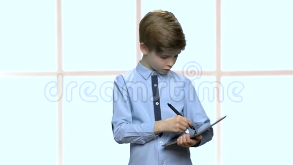 聪明的小男孩在平板电脑上写作视频的预览图