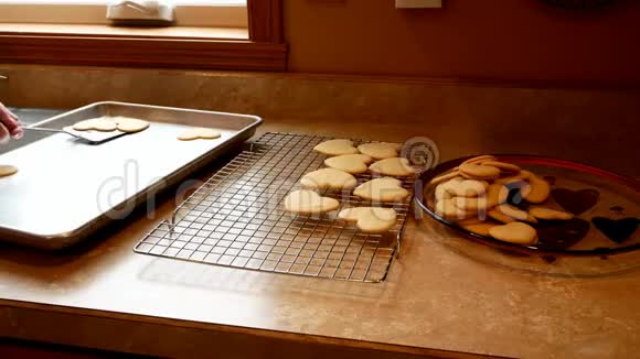 祖母美味的自制情人节糖饼干用爱和新鲜出炉转移到冷却架视频的预览图