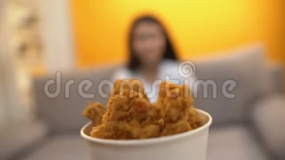 给饥饿的女孩烤鸡翅的人美味的脂肪快餐视频的预览图