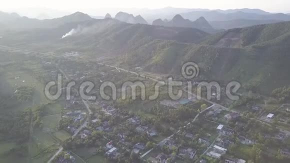 鸟瞰高地村庄靠近小湖的道路视频的预览图