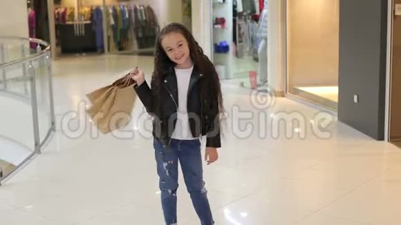 一个小女孩留着长长的卷发在购物中心的画像视频的预览图