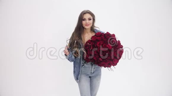 有魅力的女人拿着一束红玫瑰拍照视频的预览图