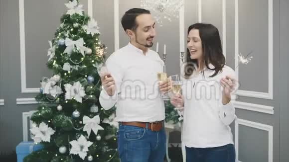 可爱和时尚的夫妇在假日气氛中站着孟加拉灯和喝香槟视频的预览图