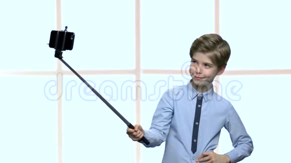 男孩与自拍棒显示无花果到相机视频的预览图