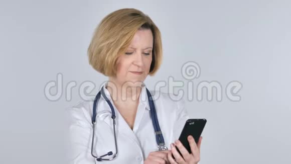 老医生与智能手机视频聊天白色背景视频的预览图