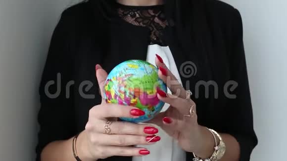 女性手握住并旋转地球的玩具球球视频的预览图