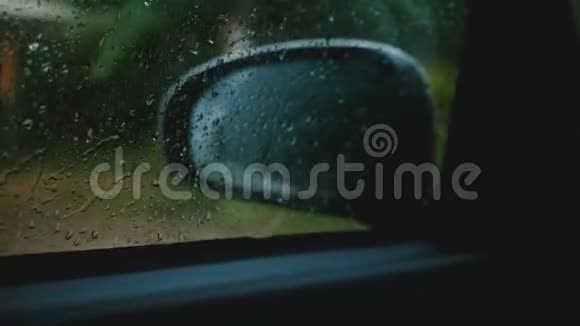 影院特写离焦侧视镜是从活动车内部看到的重点是车窗上的雨滴视频的预览图