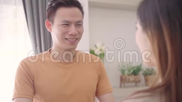 慢动作亚洲夫妇在家客厅听音乐时跳舞甜蜜的夫妇享受爱情的时刻视频的预览图