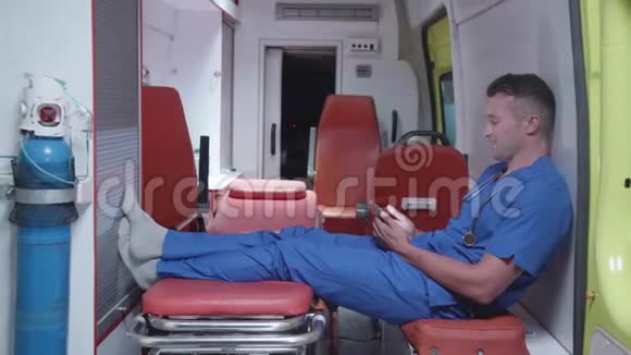 男人坐在救护车里看着什么微笑着视频的预览图