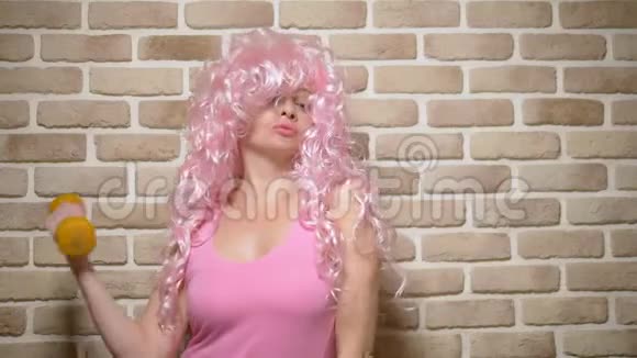 有着粉红色卷发的疯狂女孩用二头肌抵住砖墙复制空间幽默的概念冒险视频的预览图