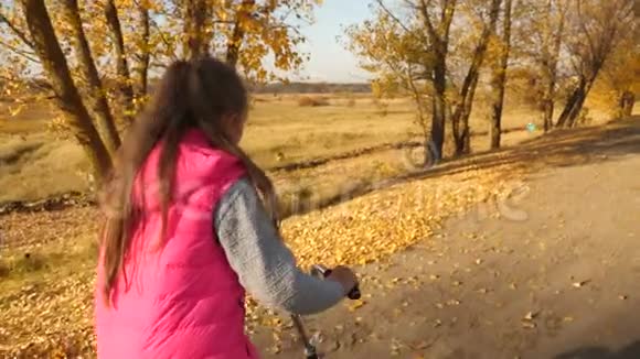 少女在秋天的公园里学骑自行车女孩的手握住弯曲的车把视频的预览图
