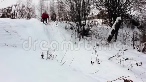 穿红夹克的女孩在雪地里滑雪视频的预览图