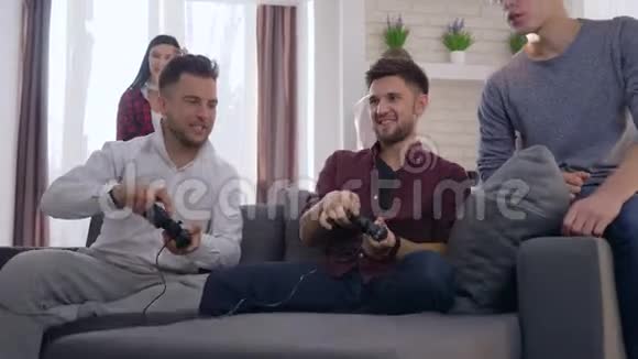游戏玩家聚会快乐的朋友男人和女人玩电脑游戏在家玩零食享受胜利视频的预览图